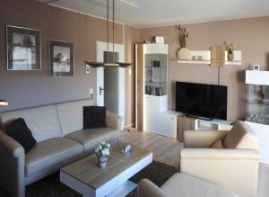 una sala de estar con un sofá y una mesa en FeWo Pieck mit Parkplatz und privater Garage, en Winterberg