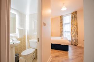 uma casa de banho com um WC, um lavatório e uma cama em Long Walk Gem em Galway