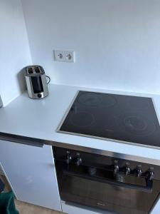 a stove top oven in a white kitchen at Zentral gelegene Wohnung nahe Flughafen und Messe in Filderstadt