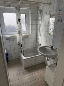 a bathroom with a bath tub and a sink at Zentral gelegene Wohnung nahe Flughafen und Messe in Filderstadt