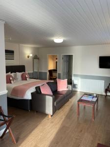una camera da letto con un letto, un divano e un tavolo di The Claymore Guest House a Pitlochry