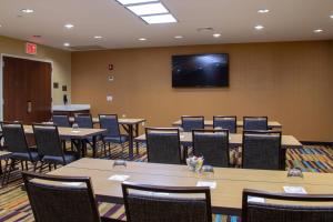 une salle de conférence avec des tables, des chaises et une télévision dans l'établissement Fairfield Inn & Suites by Marriott New York Queens/Fresh Meadows, à Queens
