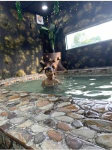 a boy swimming in a pool of water at RALI PD HOME D 16Pax karaoke and swimming pool in Port Dickson