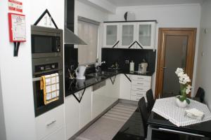 eine Küche mit weißen Schränken und einem schwarzen Herd mit Backofen in der Unterkunft Apartamento Batista in Funchal
