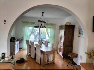 a dining room with a table and chairs and an archway at L'Olivier in Bages