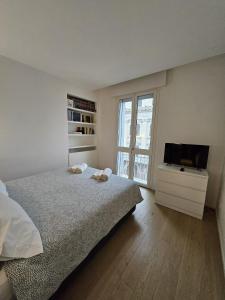 a bedroom with a bed and a tv and a window at Zen Apartment Storione in Padova
