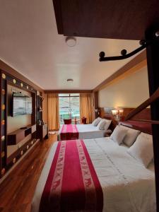 a hotel room with two beds and a large window at Hs Tierra In in Machu Picchu