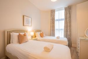 duas camas em um quarto com janela em Long Walk Gem em Galway