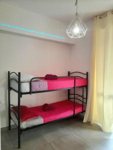 um quarto com 3 beliches com lençóis vermelhos em -L' Oasi Del Turista, Room 4- CENTRAL STATION em Milão