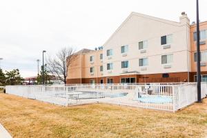 a building with a white fence in front of a building at Fairfield Inn by Marriott Ponca City in Ponca City