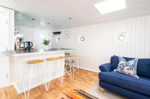 a living room with a blue couch and a kitchen at Lorna, Houseboat , West Mersea in West Mersea