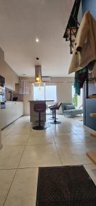 a living room with a table and a kitchen at Casa Bellissima wifi et smart TV et chambre climatisée in La Machine +14 photos