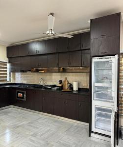 a kitchen with brown cabinets and an open refrigerator at B4 Rentals in Accra