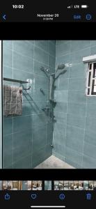 a bathroom with a shower with a glass door at B4 Rentals in Accra +7 photos