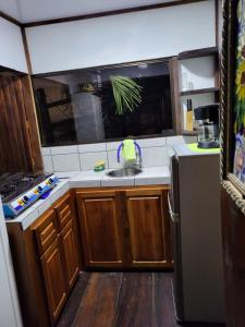a small kitchen with a sink and a refrigerator at Cabana Luna in Jicaral