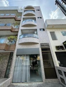GuarabiraFlat Suíte com varanda的一座带门的建筑,里面装着连衣裙