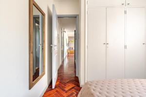a hallway with a bed and a mirror on a wall at Modern apartment in front of Plaza Independencia in Mendoza