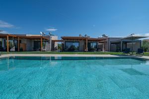 a large swimming pool in front of a house at Irissa Suites in Paralía Iríon