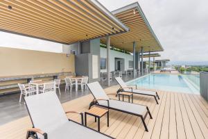 an outdoor deck with chairs and a swimming pool at Punto Novo in Nuevo Vallarta 