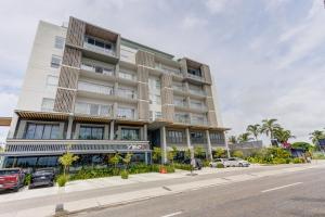 a building on a street with cars parked in front of it at Punto Novo in Nuevo Vallarta 
