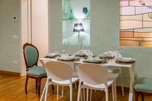 a dining room with a white table and chairs at SUPER CENTRAL - Antique flat in Bologna