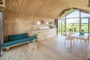a living room with a blue couch and a table at Lakehouses luxe family holiday house 6 pers in Oud-Ade