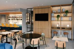a restaurant with tables and chairs and a flat screen tv at Four Points by Sheraton Matosinhos in Matosinhos