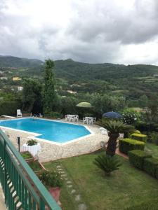 a swimming pool with tables and umbrellas in a yard at Villa Letizia in San Lucido