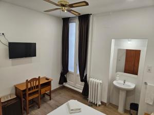 马德里米拉尔瓦旅馆的一间带桌子、水槽和吊扇的浴室 更多40张照片