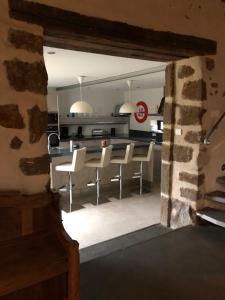 Una cocina con una mesa y sillas en una habitación. en Maison spacieuse avec piscine chauffée, en Souillé