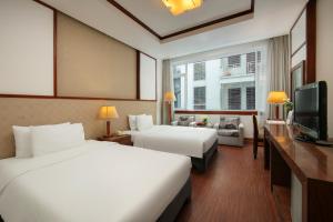 a hotel room with two beds and a television at Sao Mai Boutique Hotel in Hanoi +92 photos