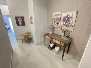 einen Flur mit einem Tisch mit Blumen drauf in der Unterkunft Casa Gaia - Proppro SRL - Vicino Milazzo in San Biagio