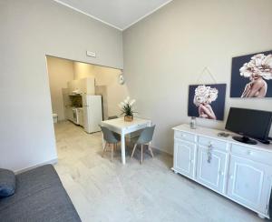 Zimmer mit einem Tisch und einem Schreibtisch mit einem TV in der Unterkunft Casa Gaia - Proppro SRL - Vicino Milazzo in San Biagio