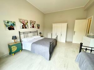 ein Schlafzimmer mit zwei Betten und einem Tisch mit Lampe in der Unterkunft Casa Gaia - Proppro SRL - Vicino Milazzo in San Biagio