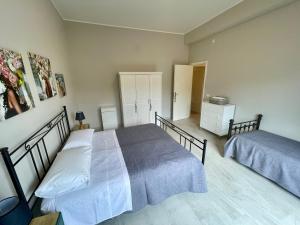 ein Schlafzimmer mit zwei Betten und einer Kommode in der Unterkunft Casa Gaia - Proppro SRL - Vicino Milazzo in San Biagio + 2 Fotos