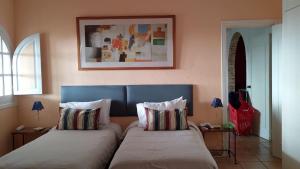a bedroom with two beds and a picture on the wall at Villa Tranquilla in Estepona