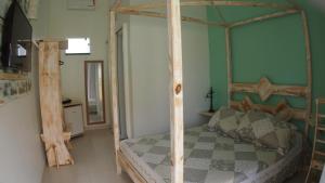 1 dormitorio con cama de madera con dosel en una habitación en Aloha Itaúna, en Saquarema