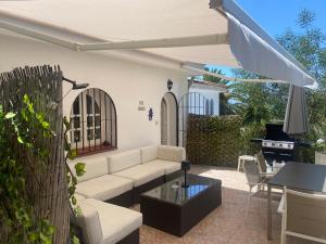 a patio with a couch and a table and a grill at Villa Tranquilla in Estepona