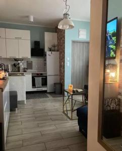 eine Küche mit weißen Schränken und einem Tisch im Zimmer in der Unterkunft Apartament Szum Fal przy Plaży Międzyzdroje in Misdroy