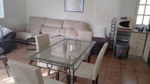 a living room with a glass table and a couch at Villa Tranquilla in Estepona