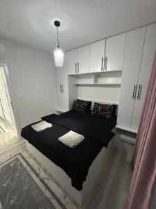 a bedroom with a black bed with white cabinets at Sweet Holiday in Mostar