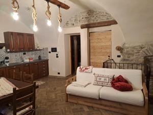 a living room with a couch and a kitchen at La Maison du Coeur - Romantic Holiday in Oulx
