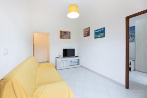 a living room with a couch and a tv at Casa Elisabetta - Goelba in Portoferraio +5 photos