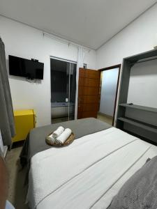a bedroom with a bed with two towels on it at Pousada Pé na Areia in Abraão