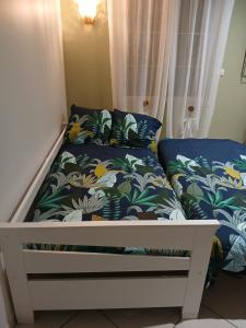 - un lit avec des draps bleus et blancs et un lit avec des oreillers dans l'établissement Au détour des Orchidées, à Artannes-sur-Indre