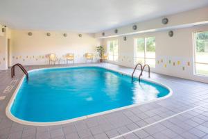 a large pool in a hotel room with blue water at Fairfield Inn & Suites by Marriott Terre Haute in Terre Haute
