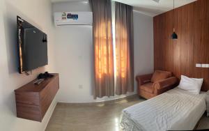 a bedroom with a bed and a tv and a chair at sama alsadah in Salalah