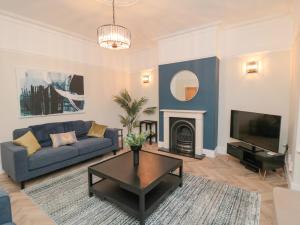 a living room with a blue couch and a fireplace at 29 Garnet Street in Saltburn-by-the-Sea
