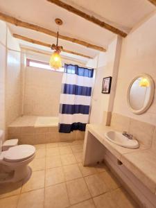 パラカスにあるCasa Charme en la Residencial de Paracasのトイレ、洗面台、浴槽を備えたバスルーム