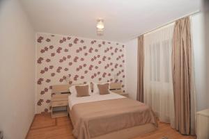 a bedroom with a bed and a wall with flowers at Casa Alexa in Sinaia